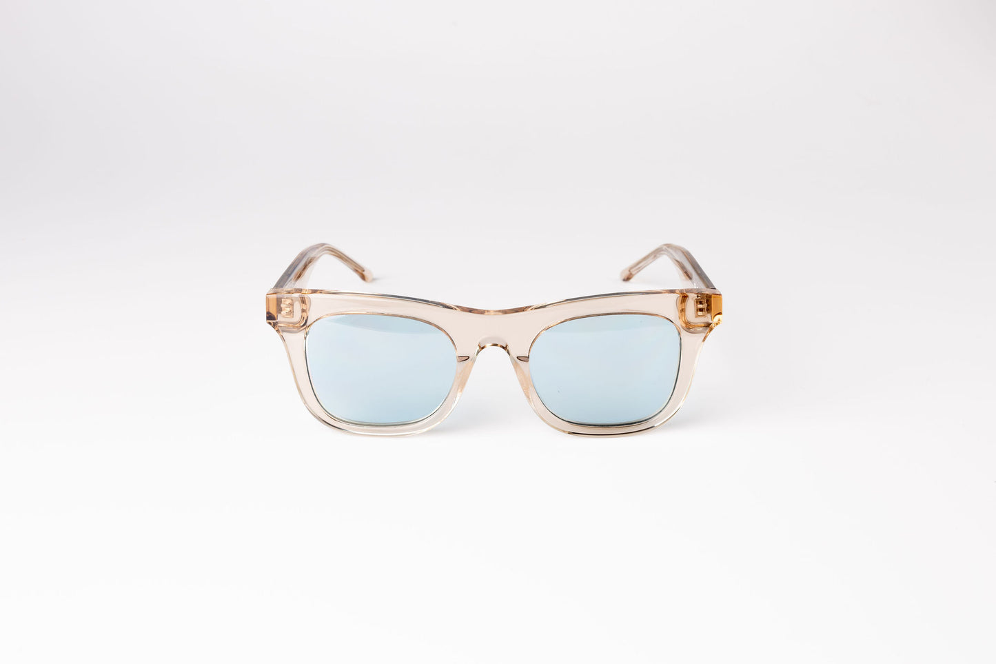 front view of peach clear biodegradable and sustainable ike oat clue sunglasses with blue lens